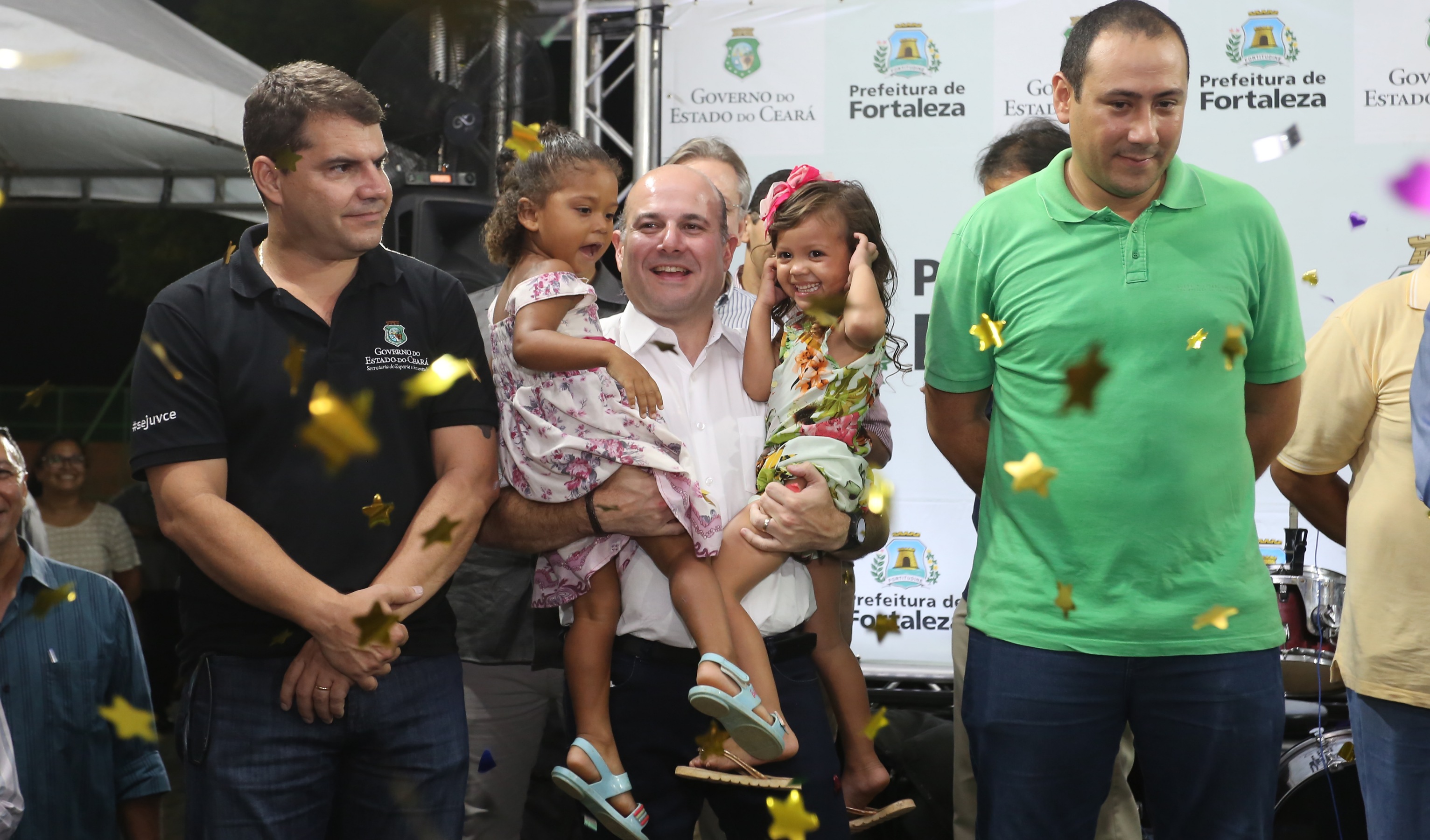 prefeito roberto cláudio segura duas crianças nos braços